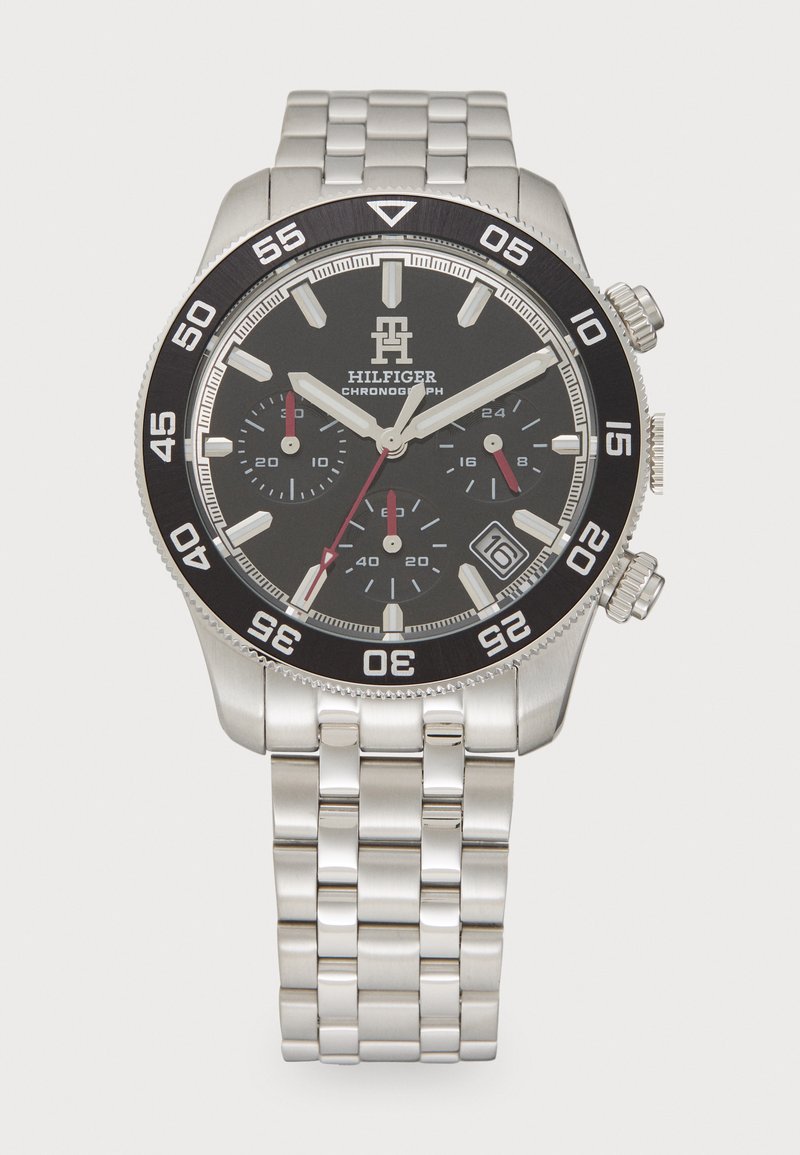Silberner Chronograph aus Edelstahl mit schwarzem Zifferblatt, silbernen und roten Akzenten, drei Unterzifferblättern und einer Datumsanzeige auf 4 Uhr.