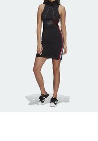 Černé bezramínkové šaty s vysokým výstřihem, zdobené vícebarevnými pruhy a centrálním grafickým logem. V kombinaci s černými teniskami.