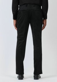 Black patterned trousers with a textured fabric, featuring two back pockets and a straight leg design. Thick waistband with belt loops.