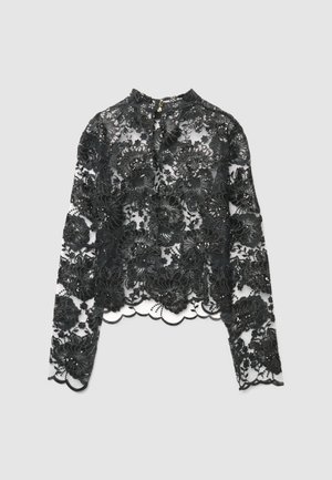 Blusa nera a maniche lunghe in pizzo con ricami floreali, presenta un orlo smerlato e un collo alto con chiusura ad occhiello.