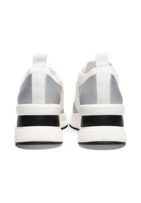 Białe i szare sportowe sneakersy o smukłym designie, teksturowanej cholewce i kontrastujących czarnych akcentach na pięcie. Logo wyeksponowane na pięcie.