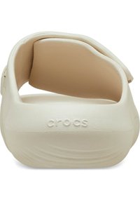 Des Crocs blancs avec une finition lisse et mate et un intérieur légèrement texturé. Comprend un dos rembourré et un logo en relief sur le côté.