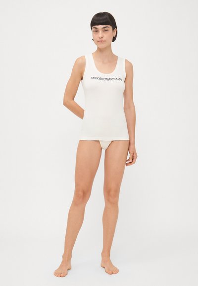 Hvit tanktop med dyp utringing, laget av myk bomull, med en svart "Emporio Armani" logo over brystet.