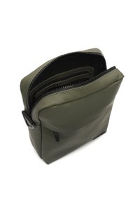 Kompaktna maslinasto zelena crossbody torba s crnim zatvaračem, otvorena kako bi prikazala unutarnje odjeljke i utore za kartice, na bijeloj pozadini.