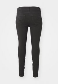 Black skinny jeans with a smooth texture, featuring a mid-rise waistband and two back pockets. No visible hardware or patterns.