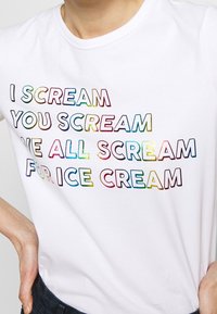 White cotton t-shirt featuring multicolored text: "I SCREAM, YOU SCREAM, WE ALL SCREAM FOR ICE CREAM" in playful fonts. Short sleeves and crew neck.