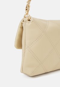 Borsa a mano in pelle beige con design trapuntato, dotata di finiture color oro e tracolla a catena. Texture liscia e forma compatta.