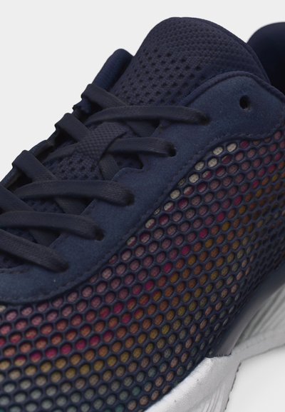 Σκούρο μπλε αθλητικό παπούτσι με υφασμάτινη πλευρά με πολύχρωμη υποκείμενη στρώση, σκουρό μπλε κορδόνια και λευκή σόλα σε κοντινή όψη.