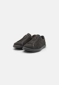 Baskets en suede gris foncé avec un design à bout rond, des lacets de la même teinte et une semelle en caoutchouc. Look minimaliste avec des accents cousus le long des côtés.