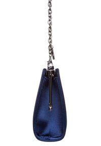 Mörkblå sammet aftonväska med silvermetallklämma och kedjesnor, hängande mot en vit bakgrund.