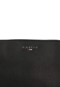 Clutch nera in pelle con superficie texturizzata, caratterizzata dal logo in rilievo "GASLLE PARIS" in script argento sul fronte. Forma rettangolare.
