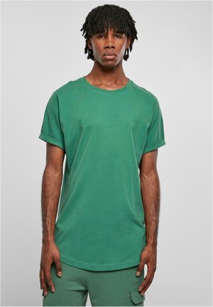 T-shirt en coton vert avec un col rond, des manches courtes et des poignets retroussés. Le tissu a une texture lisse et une coupe décontractée.
