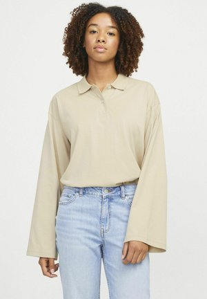 Beige long-sleeve polo shirt with a collar and three buttons, paired with light blue denim jeans. Soft cotton fabric, relaxed fit.