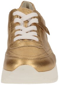 Guldmetalliskt sneaker med vita snörning, med en slät läderöverkonstruktion, vadderad sula och sydda detaljer på sidan.