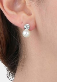 Orecchini a pendente in argento con una pietra preziosa trasparente rotonda sopra una perla bianca lucente, che mostrano un design classico con texture a contrasto.