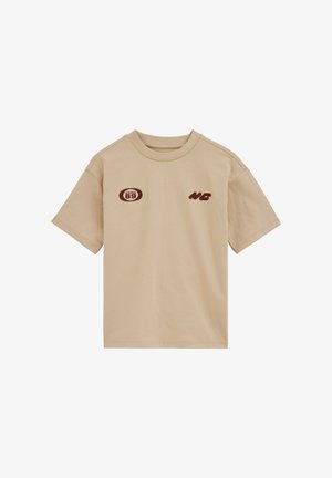 Bézs rövid ujjú póló kerek nyakkal, kis bordó "89" emblémával a bal mellrészen és "NG" kezdőbetűkkel a jobb mellrészen.