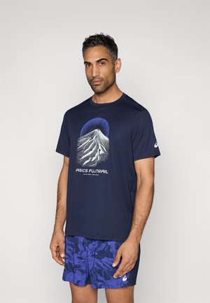 Tengerészkék rövid ujjú póló, hegy grafikával és "ASICS FUNTRAIL" felirattal, mintás kék rövidnadrággal párosítva.