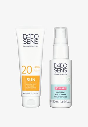 Two DADO SENS dermacosmetics products: a white tube with an orange label, and a white spray bottle with a pastel label. Both feature clear text.