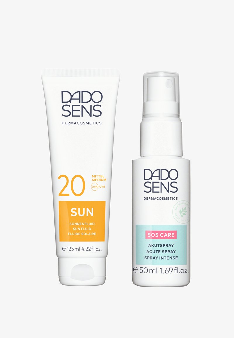 Two DADO SENS dermacosmetics products: a white tube with an orange label, and a white spray bottle with a pastel label. Both feature clear text.
