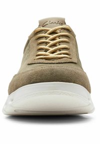 Light tan suede sneaker with a rounded toe, gold braided laces, and a white rubber sole. Features perforations on the sides for breathability.