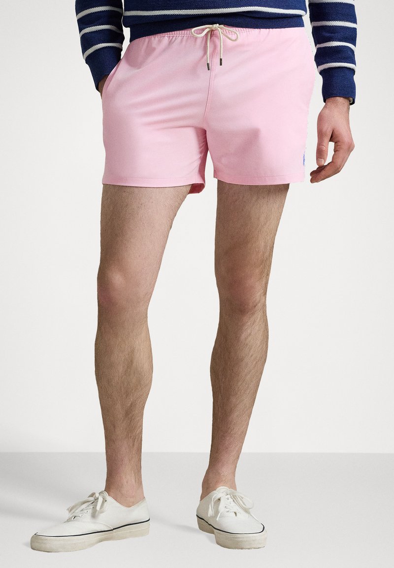 Shorts de baie roz cu talie elastică și șnur de ajustare, dotate cu buzunare laterale și un accent mic cu logo pe partea stângă frontală.