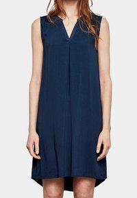 Marineblaue ärmellose Kleid mit V-Ausschnitt, aus weichem Stoff, lockerer Passform und leicht geschwungenem Saum, mit einer Mittelnaht-Details.