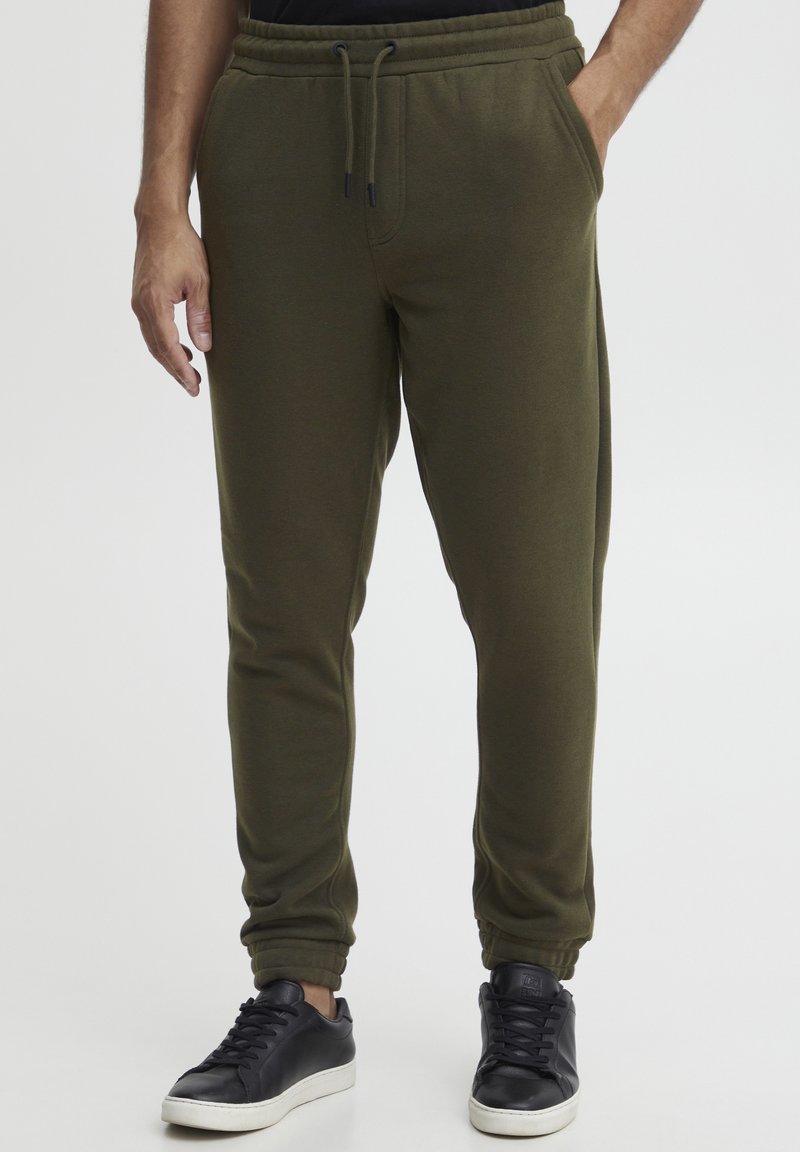 Olivgrüne Sweatpants aus weichem Material, mit einem elastischen Taillenbund und Kordelzug, Seitentaschen und schmal zulaufenden Bündchen.
