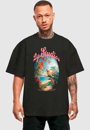 Black oversized t-shirt featuring a colorful tropical graphic with parrots, flowers, and "2y Studios" text in a retro style.