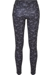 Musta leggingit, joissa on valkoinen kukka- ja köynnöskuvio, sileää ja joustavaa kangasta sekä istuva malli ilman taskuja.