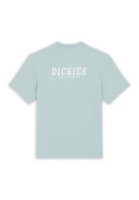 Camiseta de algodón azul claro con mangas cortas. La parte trasera presenta texto blanco que dice "DICKIES" y "CONSTRUIDO PARA DURAR DESDE 1922." Diseño simple.