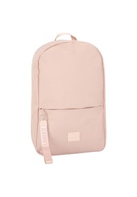 Light pink backpack made of fabric, featuring a smooth texture, rounded shape, and front zip pocket with a branded zipper pull.