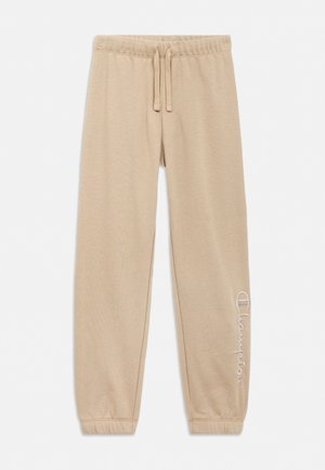 Beige sweatpants met elastische tailleband en trekkoord, elastische boorden en wit "Champion"-logo op het onderbeen aan de rechterzijde.