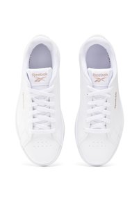 Białe sneakersy Reebok z gładką skórzaną cholewką, teksturowanym językiem, płaskimi sznurówkami, perforacjami na przodzie buta oraz akcentami w kolorze różowego złota.