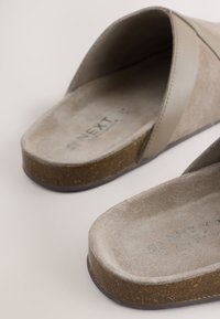 Sandales beige en daim à enfiler avec semelles en liège rembourrées et larges brides, de marque "NEXT", présentées sur un fond uni.