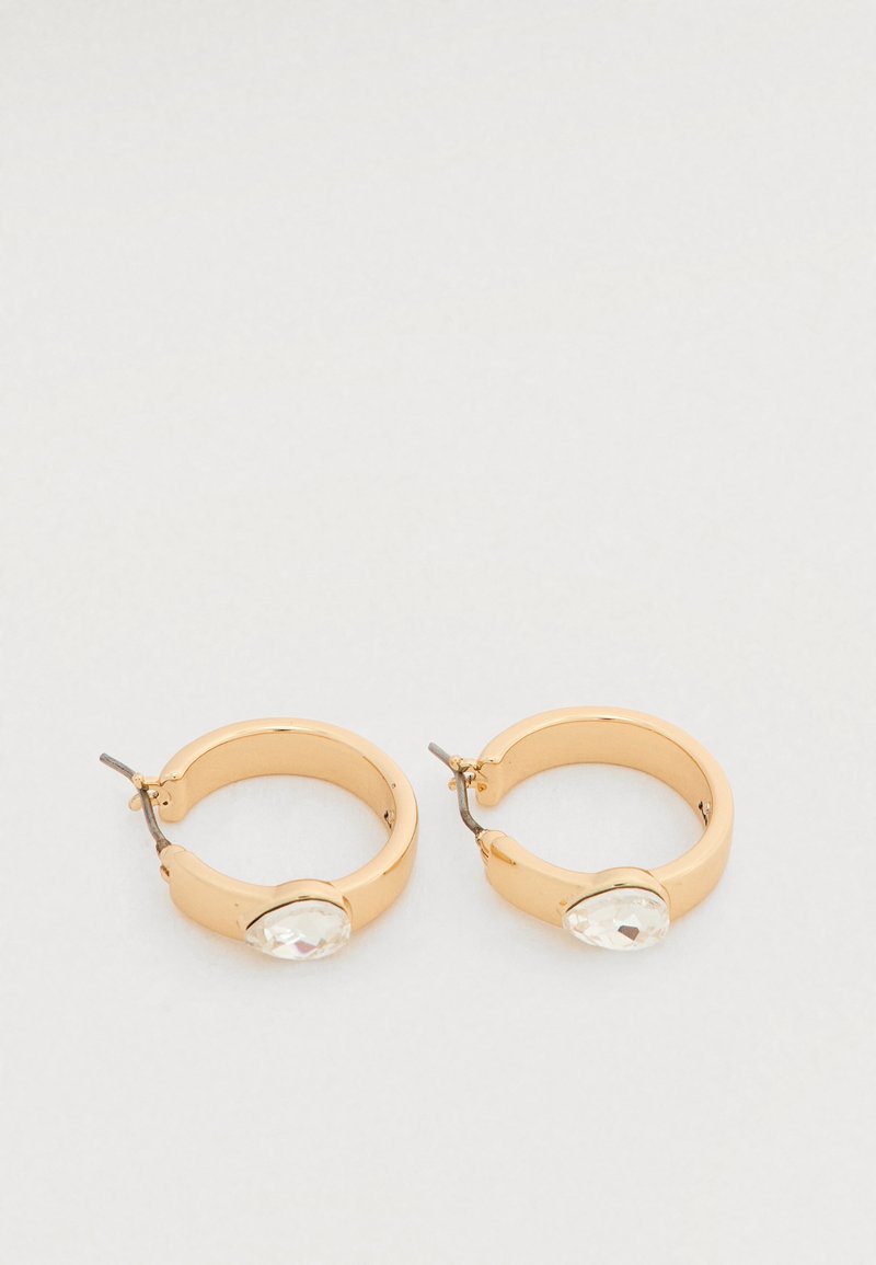 Χρυσά σκουλαρίκια κρίκοι με λείο φινίρισμα και μεγάλο, διαυγές διακοσμητικό λίθο σε σχήμα σταγόνας σε κάθε σκουλαρίκι.