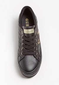 Schwarze, gesteppte Sneaker aus glattem Leder mit einer goldfarbenen Metall-Logoplakette, runder Zehenpartie und schwarzen Schnürsenkeln. Seitliche Reißverschluss-Akzente setzen Details.