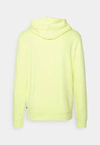 Tył jasnos żółtej bluzy z kapturem z długimi rękawami, ściągaczami na mankietach i kapturem, na prostym białym tle.