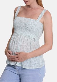 Leichtes, blumenmusterndes Umstandstop mit gerafftem Oberteil, breiten Trägern und einem seitlichen Reißverschluss. Der Stoff ist leicht und atmungsaktiv.