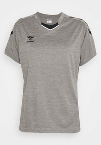 Maglia sportiva grigio chiaro con maniche corte, logo hummel nero sul petto, disegni a chevron neri sulle spalle e dettaglio collo a V.