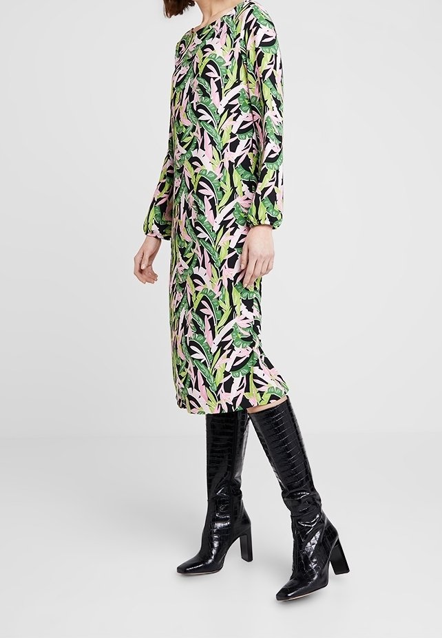 Floral dress with green, pink, and black leaves; long sleeves, knee-length, round neckline, paired with shiny black knee-high boots.