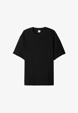 Black ribbed short-sleeve t-shirt with a round neck, featuring a relaxed fit and textured surface. Simple design; no graphics or accents.