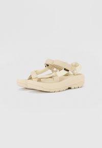 Beige sandaler med en tykk, teksturert såle, med justerbare stropper for sikker passform. Minimalistisk design med en glatt finish.
