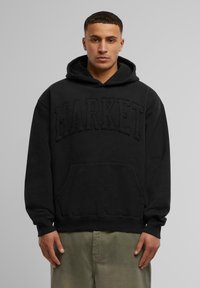 Schwarzer Kapuzenpullover mit einer strukturierten "MARKET"-Logoprint auf der Brust, einer Vorderasche und gerippten Bündchen. Strukturierter Stoff.
