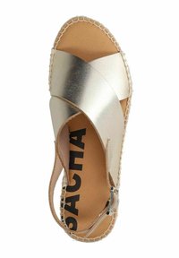 Metalen gouden espadrille sandaal met kruislings banden, een gestructureerde zool en een gespsluiting. Heeft een geweven rand voor extra detail.