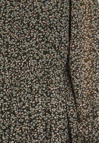 Robe noire à motifs floraux, en tissu texturé, ornée de petites fleurs éparpillées dans des teintes de blanc, rose et vert ; fronces à la taille.