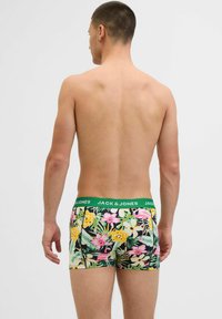 Männer Boxer-Shorts mit einem tropischen Blumenmuster in Gelb, Pink und Grün; der grüne elastische Bund trägt das Branding "JACK & JONES".