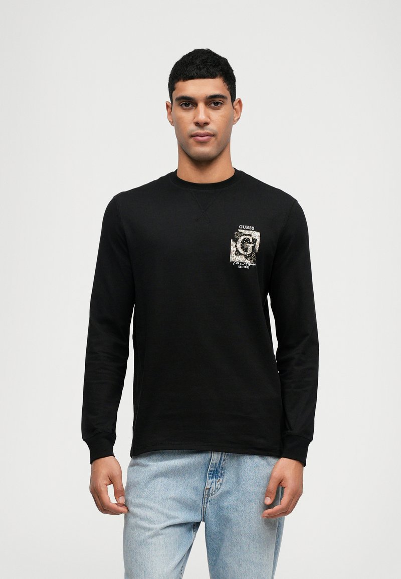 Sweatshirt preto de manga longa com um bolso frontal e um logótipo padrão. Corte clássico com decote redondo e punhos canelados. Design casual.