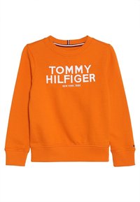 Oranžová mikina s dlouhým rukávem, s žebrovanými manžetami a spodním okrajem, na přední straně nápis "TOMMY HILFIGER NEW YORK, 1985" v bílé barvě.