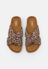 Sandaalit, joissa on leopardinprinttikuosiset ja solmeutavalla varustetut nauhat, joissa on pehmeä ruskea tekosuurikangas pohja ja neutraali beige ulkopohja.
