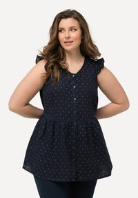 Top senza maniche blu navy con pois bianchi, apertura con bottoni sul davanti, dettagli arricciati sulle spalle e vita arricciata per un fit rilassato.